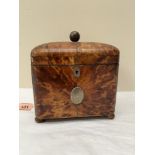 A George III tortoisehell tea caddy, the domed lid enclosed two lidded compartments, raised on bun