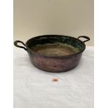 A 19th century copper two handled pan. 23' wide over handles