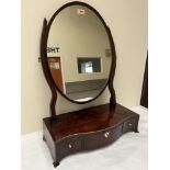 A George III mahogany dressing table mirror with oval plate, the serpentine base with three drawers.