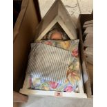 A box of curtains with a doll in a cradle