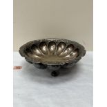 A white metal and repousse decorated bowl on ball and claw deet. 12' diam.