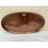 Hugh Wallace. An Arts and Crafts planished copper oval tray with gadrooned rim. HW mark. 20¼'