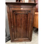 An 18th century oak hanging corner cupboard enclosed by a panel door. 41' high