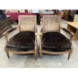 A pair of French bergere armchairs with caned seats and scroll carved arms, on fluted tapered legs