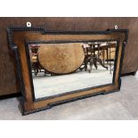 An oak and ebonised wall mirror with bevelled plate. 36' wide