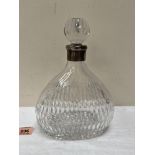 A cut glass decanter with white metal mount. 9' high