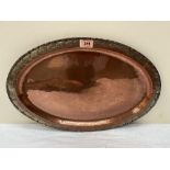 Hugh Wallace. An Arts and Crafts copper oval dish with planished cavetto. HW mark. 20' wide