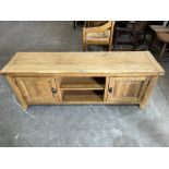 A light oak low cupboard with recess flanked by cupboard doors. 59' wide