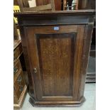 An 18th century oak hanging corner cupboard enclosed by a mahogany banded panel door. 42½' high
