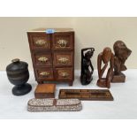 A brass mounted miniature chest of drawers; a decorated pen box; a treen box; three carved wood