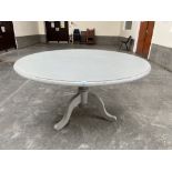 A grey painted birch dining table, ('Faience' by Coach House), raised on a tripod support. 54'