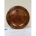 An Arts and Crafts Newlyn style planished copper dish embossed with fish. 12' diam.
