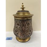 A Persian brass and silvered copper lidded jar with chased decoration. 8¼' high