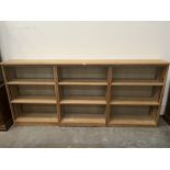 A light oak open bookcase in three sections, each part with two adjustable shelves. 102'w x 45'h