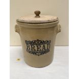 A stoneware bread crock with carved pine cover. 16½' high. Handle restored, area of damage to the