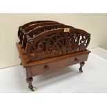 A Victorian walnut music canterbury with three scroll fret carved divisions over a base drawer.