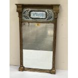 A Regency gilt pier glass, the frame with ionic pilasters enclosing a verre-eglomise panel painted
