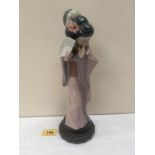 A Lladro figure of an oriental lady. 11¾' high