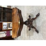 A Victorian rosewood card table, the serpentine shaped moulded top on carved baluster column on