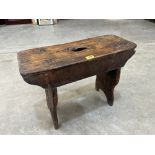 A 19th century primitive stool with pierced seat on shaped trestle supports. 23' long