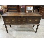 A George III oak dresser base with three drawers, raised on chamfered square legs 54' wide