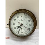 A brass maritime bulkhead clock with key wound movement, the enamel dial with Arabic numerals and