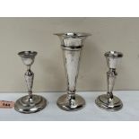 A George V silver trumpet vase, Birmingham 1919, 6½' high, together with two silver candlesticks.