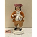 A 19th century Staffordshire figure of a rotund gentleman with mug of beer wearing a tricorn hat.