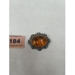 A silver and amber brooch. 36mm wide