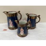 Three Victorian copper lustre graduated jugs, decorated with figures in relief on a blue ground. The