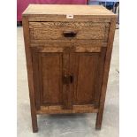 An oak cabinet enclosed by a pair of panel doors under a drawer in the style of Heals. 22' wide