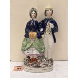 A 19th century Staffordshire earthenware group, lady with hand muff and gentleman companion. 9½'