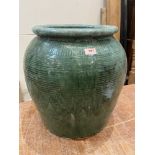 An earthenware green glazed pot. 19' high