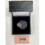 A Turkish yellow metal ring, set with a blue hardstone intaglio. Size P½'