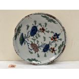 An 18th century Delft tin glazed earthenware dish, polychrome decorated in manganese, blue and other