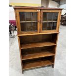 A walnut bookcase enclosed by a pair of leaded glazed doors over three open shelves. 31' w x 52' h