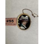 A 19th century 18ct brooch painted with a lady in wide brimmed plumed hat. 40mm high