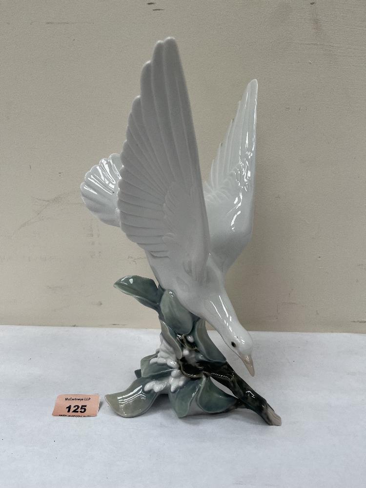 A Lladro figure of a bird alighting on a branch. 11' high