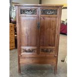 A Chinese pine wardrobe, the pair of doors with scrolled pierced or relief carved panels. 38½'w x