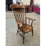 A Victorian lath-back elbow chair on splayed ring turned legs