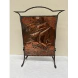 An Arts and Crafts copper and wrought iron firescreen, embossed with a sailing ship. 32' high
