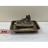 A George V silver pin or snuffbox on tray stand, the lid with applied recumbent hound. London