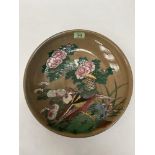 A Japanese glazed pottery charger, painted with birds, chrysanthemums and foliage on a buff