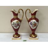 A pair of Linder ewers, painted with summer flowers in two reserves on a burgundy ground and