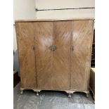 Waring & Gillows. A three piece walnut bedroom suite comprising a triple wardrobe, dressing table
