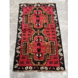 A Balochi red ground rug. 1.41m x 0.86m