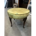 An upholstered stool on cabriole legs