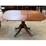 A mahogany breakfast table on ring turned column and quadripartite outswept support. 54' wide.