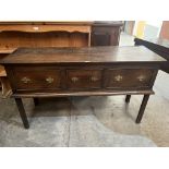 An oak dresser base with three drawers, raised on chamfered square legs 54' wide