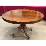 An early 19th century mahogany snap-top supper table, the associated top with beaded edge, on turned